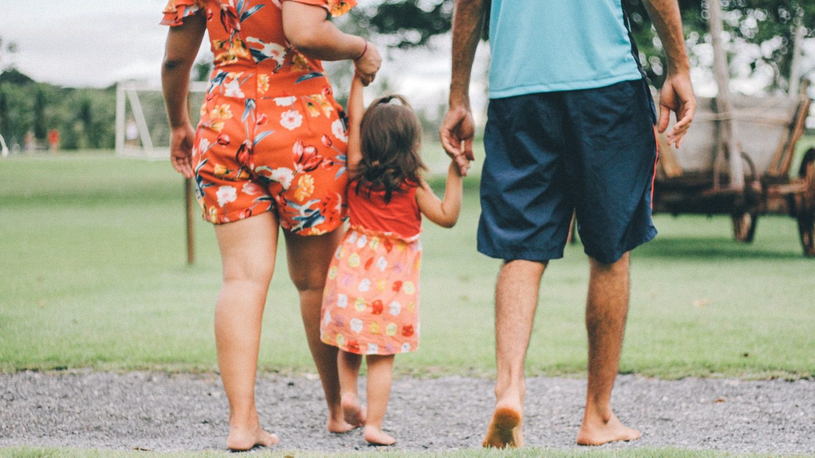 Familia feliz andando con su hija de la mano